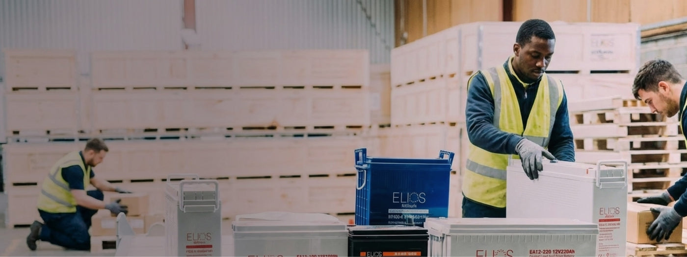 Workers packaging Solar Elios boxes in the Volts Energies warehouse with crates and boxes in the background.