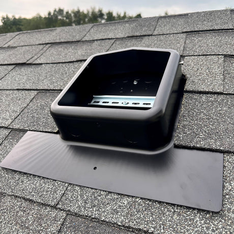 Roof-Mounted Solar PV Junction Box on a shingled roof with trees in the background