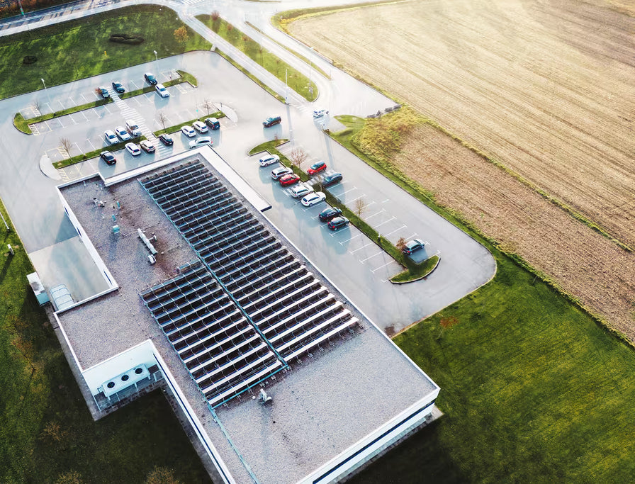 Aerial drone view of commercial building with large rooftop solar panel array for sustainable energy generation