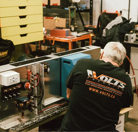 Volts Energies certified technician assembling an electrical panel and solar energy system in a workshop