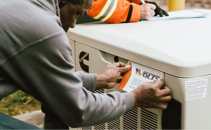 Volts Energy certified technician installing and labeling a Cummins generator during a professional energy system installation